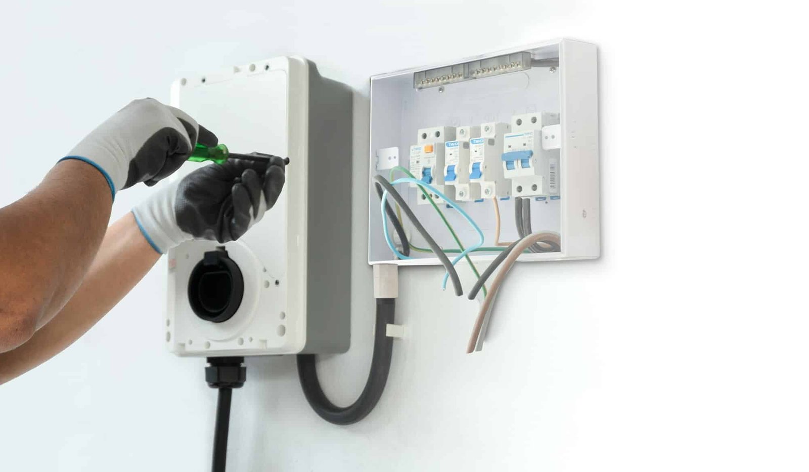 A man electrician installing a home charging, installing charging station